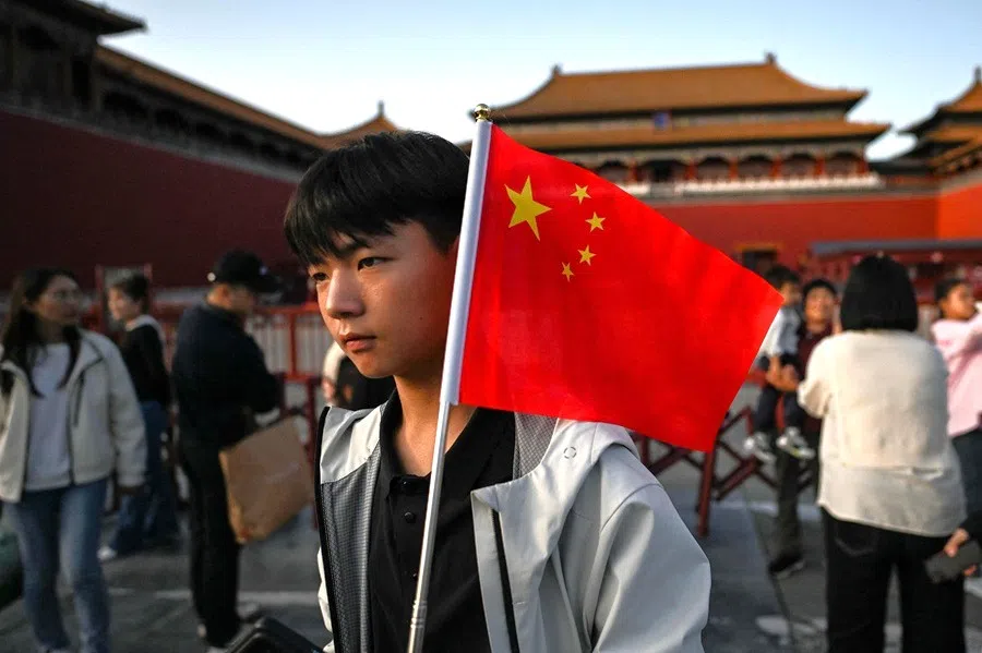 A man holds a Chinese flag in front of the Forbidden City in Beijing, China during China’s National Day Golden Week holiday on 6 October 2025.