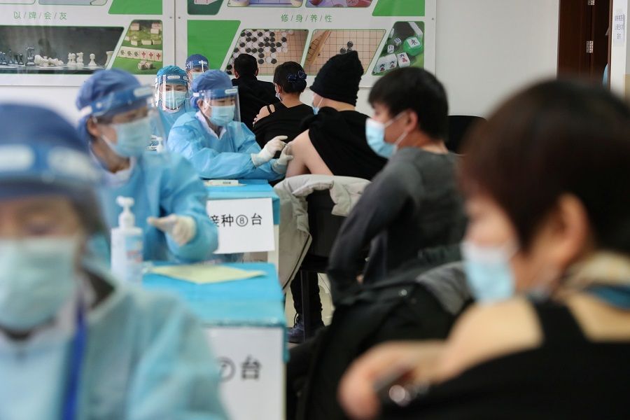 Medical workers in protective suits administer the Covid-19 vaccine at a makeshift vaccination site in Haidian district, Beijing, China, 8 January 2021. (CNS photo via Reuters)