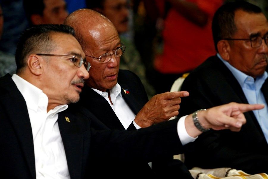 Malaysia's Defence Minister Hishammuddin Hussein (left) speaks to the Philippines' Secretary of National Defence Delfin Lorenzana during the launch of the Trilateral Air Patrol at the Royal Malaysian Air Force base in Subang, outside Kuala Lumpur, Malaysia, 12 October 2017. (Lai Seng Sin/Reuters)