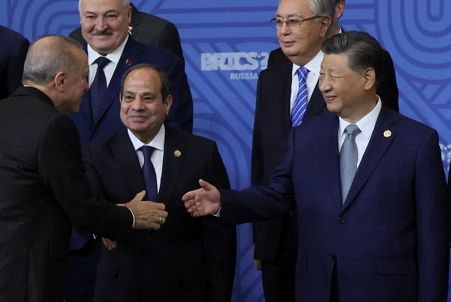 Turkish President Recep Tayyip Erdogan greets Egyptian President Abdel Fattah al-Sisi, Chinese President Xi Jinping as other participants in the outreach/BRICS Plus format meeting pose for a family photo during the BRICS summit in Kazan, Russia, on 24 October 2024. (Maxim Shipenkov/Pool via Reuters)