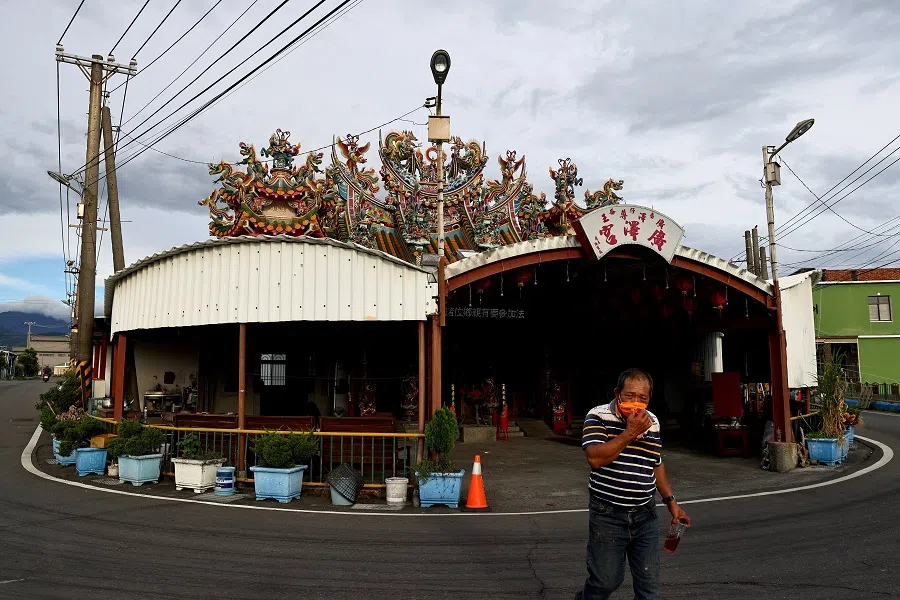 A villager adjusts his face mask while walking out of a temple at Fangliao, Pingtung, Taiwan, 9 August 2022. (Ann Wang/Reuters)