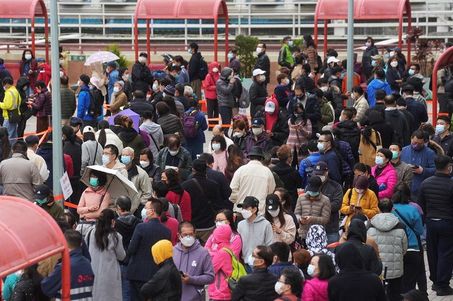 People wearing face masks queue at a community nucleic acid testing centre at Sha Tin district, in Hong Kong, 7 February 2022. (Lam Yik/Reuters)