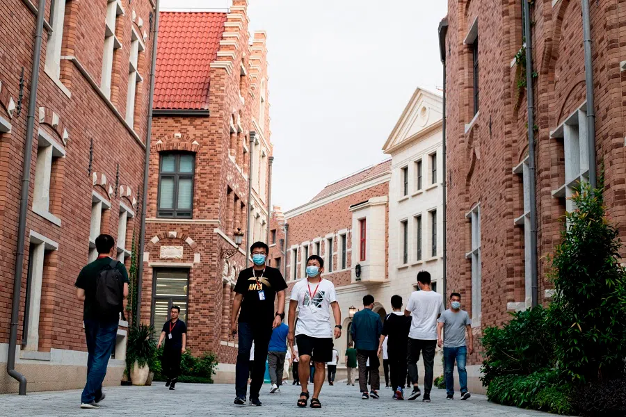 Huawei employees walk along a street of the Huawei European-themed campus in Dongguan, China on 19 May 2020. (Noel Celis/AFP)