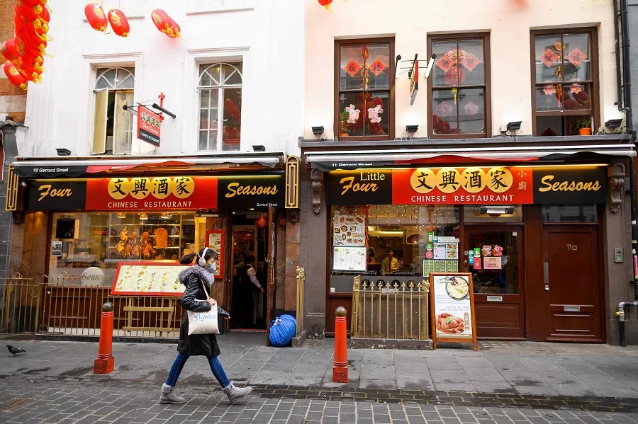 A pedestrian wears a surgical face mask as she walks past a Chinese restaurant in London's Chinatown district, on 4 February 2020. (Justin Tallis/AFP)