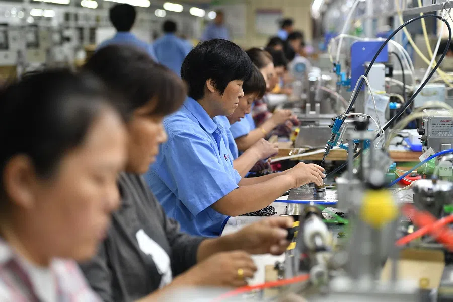 Employees work on an assembly line producing speakers at a factory in Fuyang city, in Anhui province, China, on 31 August 2022. (AFP)