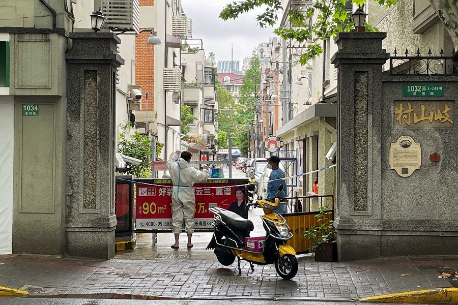 A courier in a protective suit makes deliveries to a residential compound amid the Covid-19 outbreak in Shanghai, China, 23 April 2022. (Brenda Goh/File Photo/Reuters)