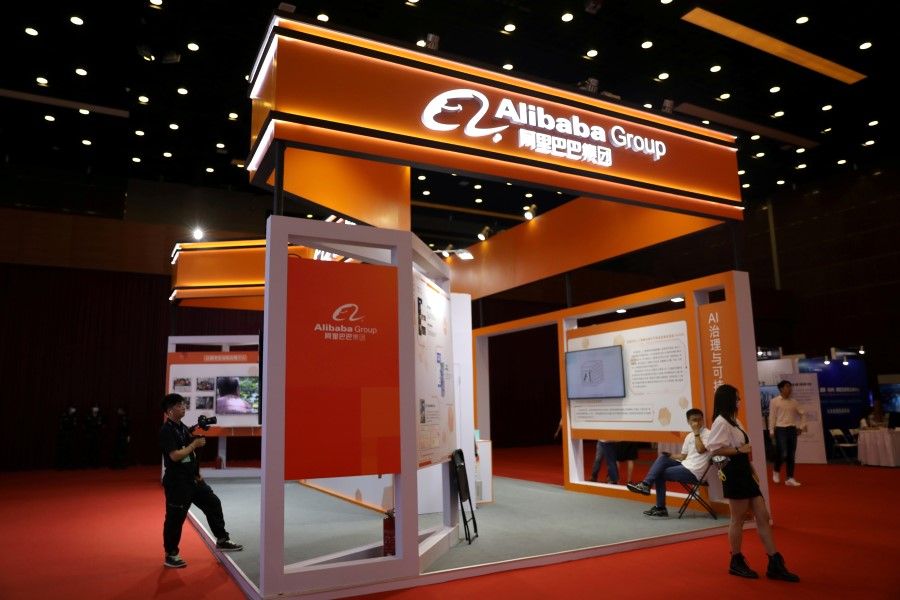People are seen at a booth of Alibaba Group at an exhibition during China Internet Conference, in Beijing, China, 13 July 2021. (Tingshu Wang/Reuters)