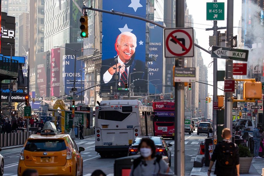 Vehicles drive past an image of US President-elect Joe Biden on a screen in the Times Square area of New York, US, on 9 November 2020. (Michael Nagle/Bloomberg)