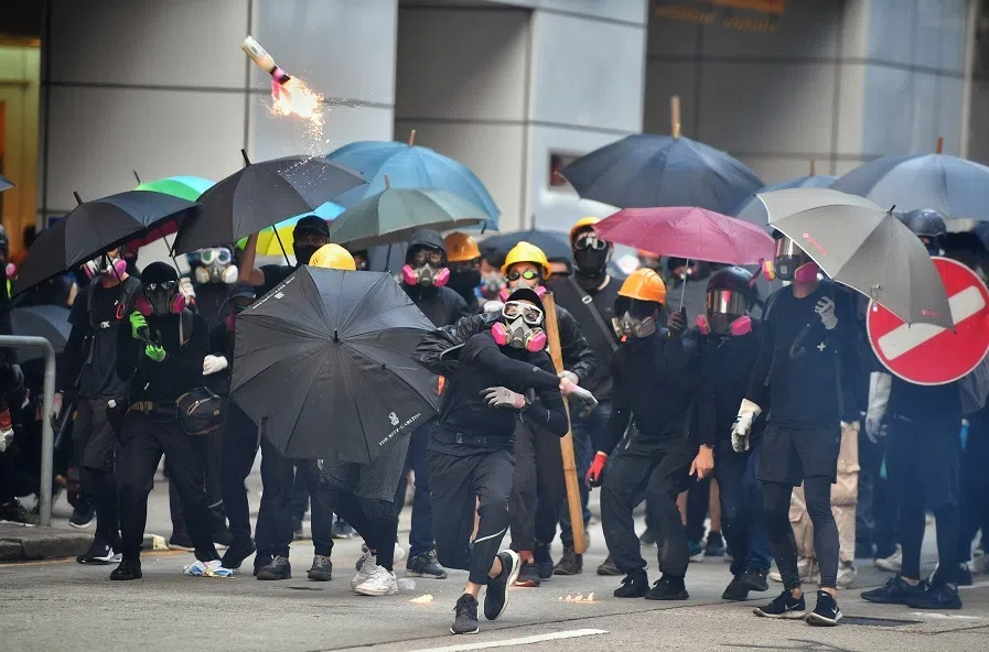 A protester throws a molotov cocktail at the Hong Kong police in a bid to slow down their advancement at Wan Chai, Hong Kong, on 29 September 2019. (SPH Media)