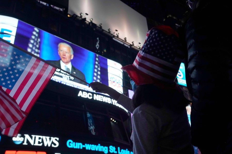 People watch the ABC Good Morning America GMA Studios videoscreen as president-elect Joe Biden gives his acceptance speech from Delaware, in Times Square, New York on 7 November 2020. (Timothy A. Clary/AFP)