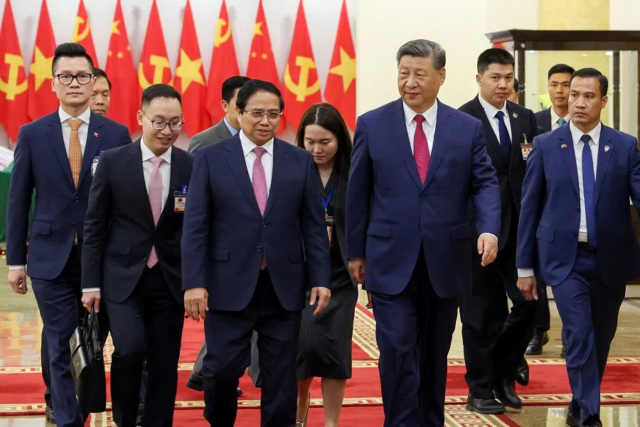 Vietnamese Prime Minister Pham Minh Chinh (centre left), and Chinese President Xi Jinping (centre right), walk to the meeting room at the Office of the Party Central Committee in Hanoi, Vietnam, on 14 April 2025.