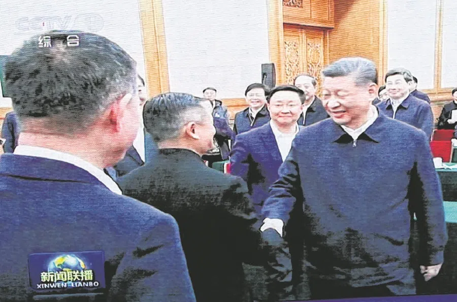 A giant screen shows news footage of Chinese President Xi Jinping shaking hands with Alibaba founder Jack Ma during a symposium on private enterprises, at a shopping complex in Beijing, China, on 17 February 2025. (Florence Lo/Reuters)
