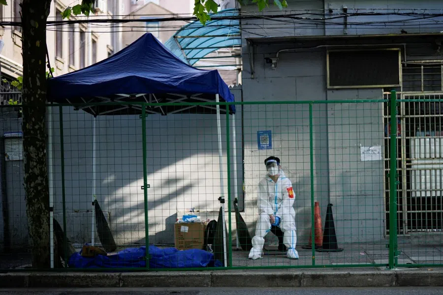 A worker in a protective suit sits at a sealed area, after the lockdown placed to curb the Covid-19 outbreak was lifted in Shanghai, China, 8 June 2022. (Aly Song/Reuters)