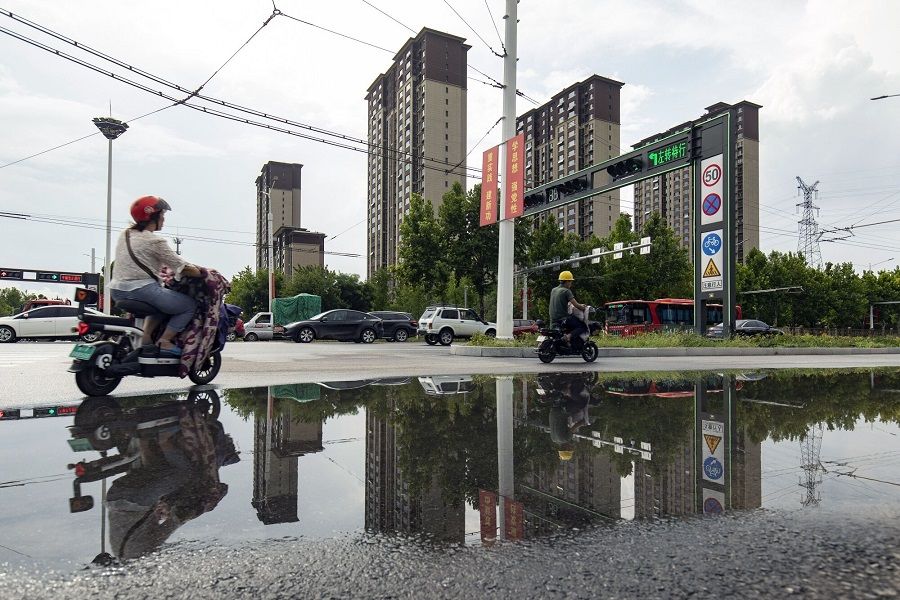 People ride past residential buildings developed by Country Garden Holdings Co. in Baoding, Hebei province, China, 1 August 2023. (Qilai Shen/Bloomberg)