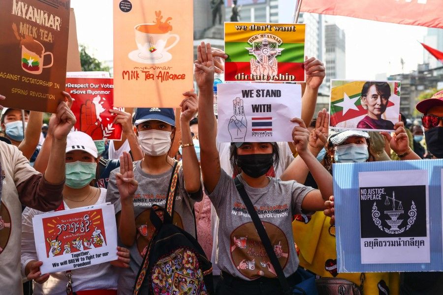 Pro-democracy protesters holds signs relating to the "Milk Tea Alliance" and the current situation in Myanmar as they take part in a demonstration before a march toward the residence of Thailand's Prime Minister Prayut Chan-O-Cha in Bangkok on 28 February 2021. (Jack Taylor/AFP)