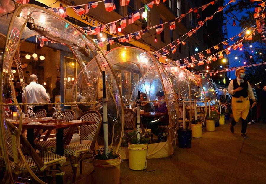 People dine in plastic tents for social distancing at a restaurant in Manhattan on 15 October 2020 in New York City, amid the coronavirus pandemic. (Angela Weiss/AFP)