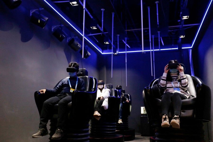 People try virtual reality goggles in Beijing, China, 10 February 2022. (Florence Lo/Reuters)