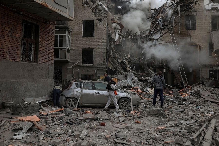 Local residents look at debris of a residential building damaged by a Russian military strike, as Russia's attack on Ukraine continues, in Kharkiv, Ukraine, 6 September 2022. (Sofiia Gatilova/Reuters)