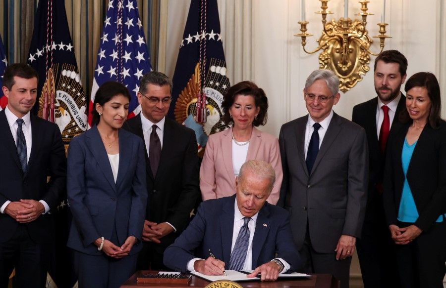 U.S. President Joe Biden signs an executive order on "promoting competition in the American economy" as members of his Cabinet standby during an event in the State Dining Room at the White House in Washington US, 9 July 2021. (Evelyn Hockstein/Reuters)