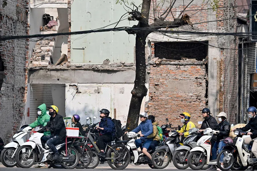 People ride their motorbike in front of old houses being demolished in Hanoi, Vietnam, on 6 January 2025. (Nhac Nguyen/AFP)