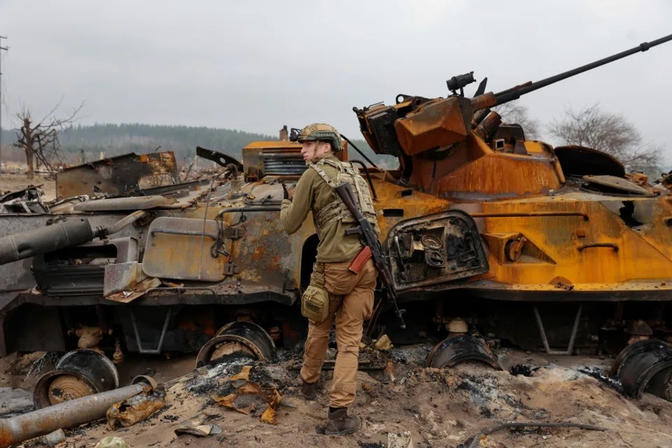 A Ukrainian service member inspects destroyed Russian BTR-82 armoured personal carrier (APC) in a village near a frontline, as Russia's attack on Ukraine continues, in Kyiv Region, Ukraine, 31 March 2022. (Serhii Nuzhnenko/Reuters)