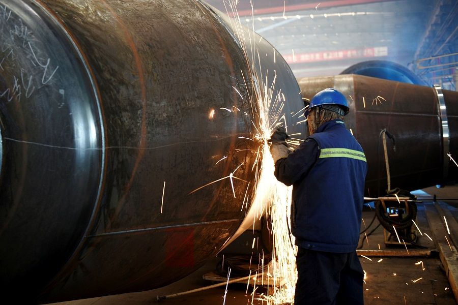An employee welds truck parts at a mixer truck manufacturing factory in Zhangjiakou, Hebei province, China, on 8 December 2020. (STR/AFP)