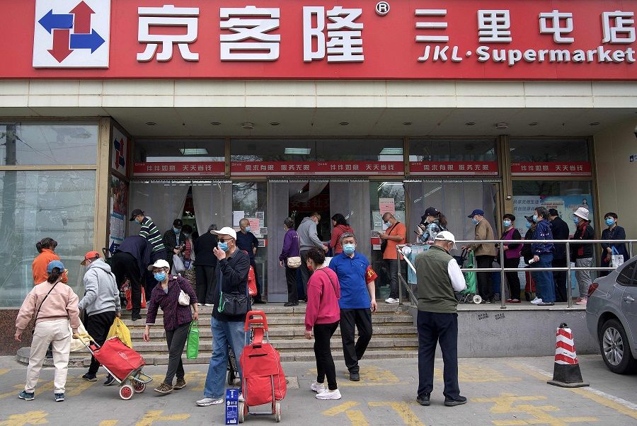 People queue outside a supermarket to buy food supplies in Beijing, China, on 25 April 2022. (Noel Celis/AFP)