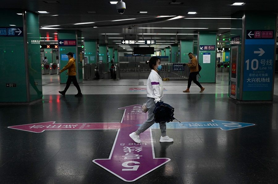 People walk through a subway station in Beijing, China, on 6 May 2022. (Wang Zhao/AFP)