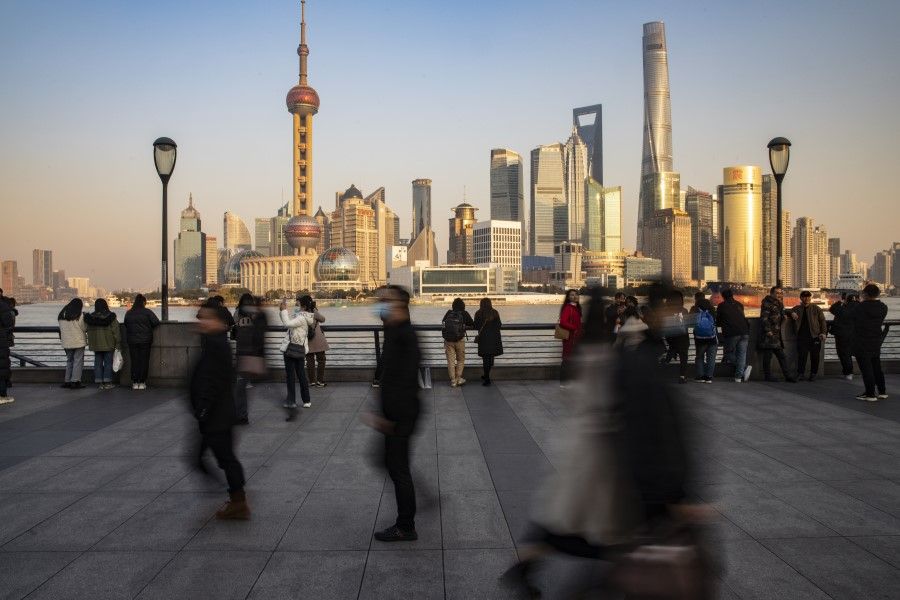 Visitors walk on the Bund in Shanghai, China, on 21 December 2020. China's central bank is striking out on its own with signals of tighter monetary policy, widening a divergence with other large economies that will shape global capital and trade flows next year. (Qilai Shen/Bloomberg)