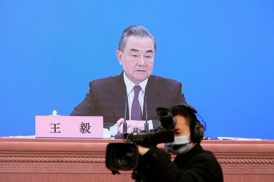 Chinese State Councilor and Foreign Minister Wang Yi is seen on a screen as he attends a news conference via video link on the sidelines of the National People's Congress (NPC), in Beijing, China, 7 March 2022. (Ryan Woo/Reuters)