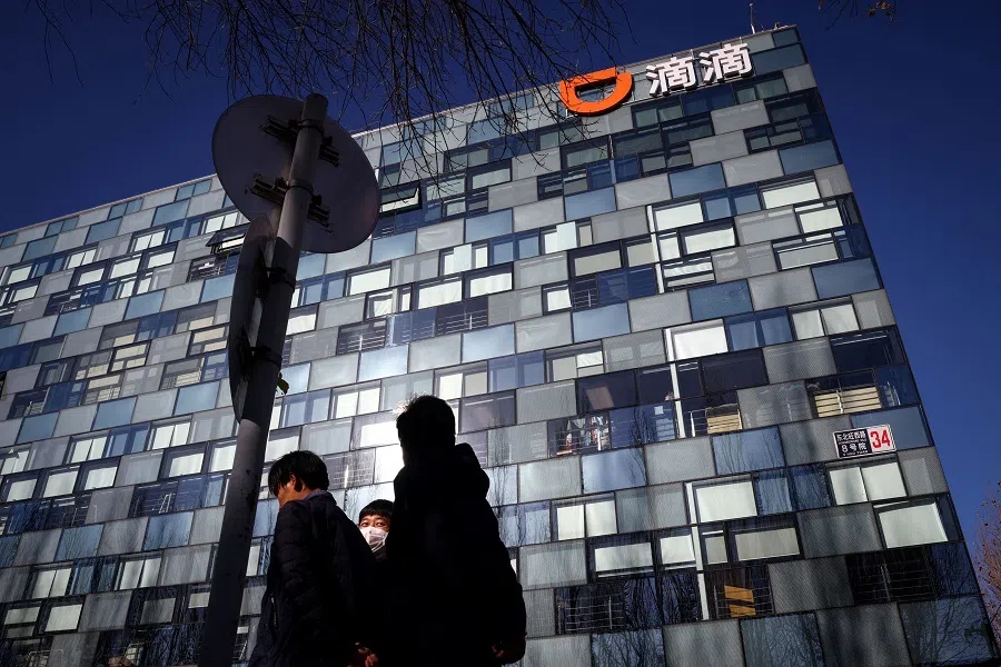 People walk past the headquarters of the Chinese ride-hailing service Didi in Beijing, China, 3 December 2021. (Thomas Peter/File Photo/Reuters)