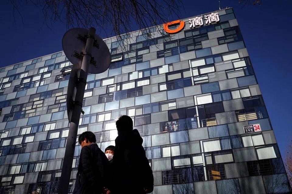 People walk past the headquarters of the Chinese ride-hailing service Didi in Beijing, China, 3 December 2021. (Thomas Peter/File Photo/Reuters)