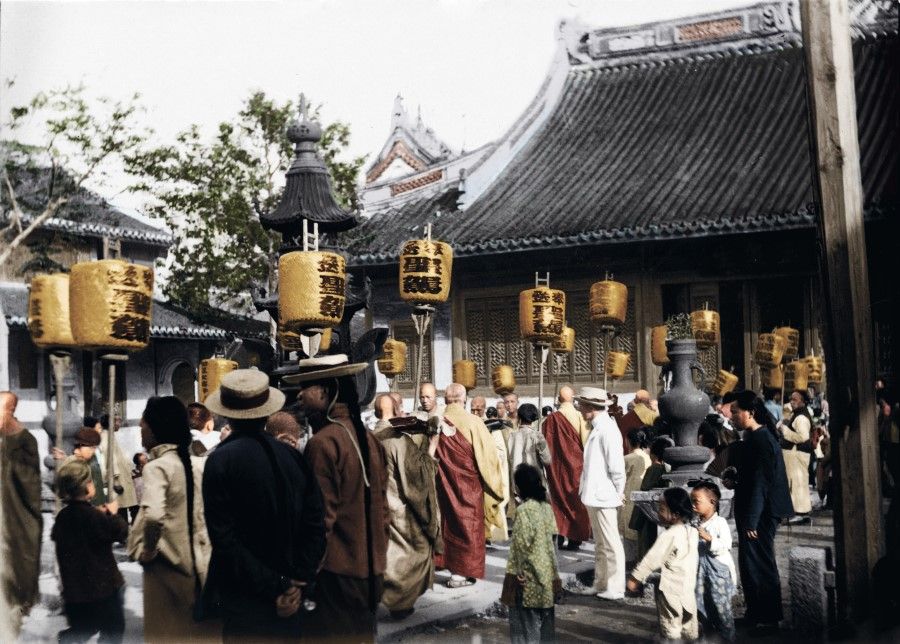 A lively scene at Shanghai's Longhua Temple (龙华寺) in the late Qing dynasty. The crowd is crammed in a side hall, watching the monks pass in grand fashion, with lanterns held high to guide the entourage.