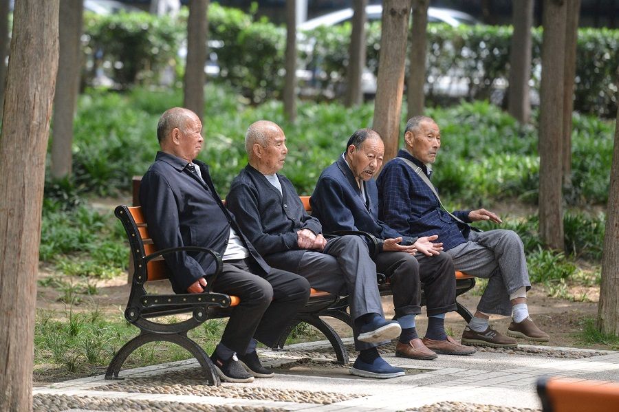 Elderly people rest at a park in Fuyang, Anhui province, China on 12 May 2021. (STR/AFP)