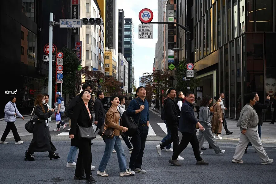 A Chinese tour group walks at the Ginza shopping district of Tokyo on 16 November 2025. China has advised its citizens to avoid travelling to Japan, following a diplomatic feud.