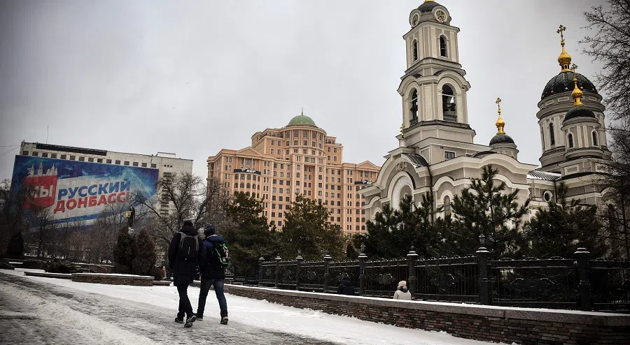 Pedestrians walk in central Donetsk, Ukraine, the capital of a self-proclaimed Donetsk People's Republic (DPR), on 19 January 2022. (Alexander Nemenov/AFP)