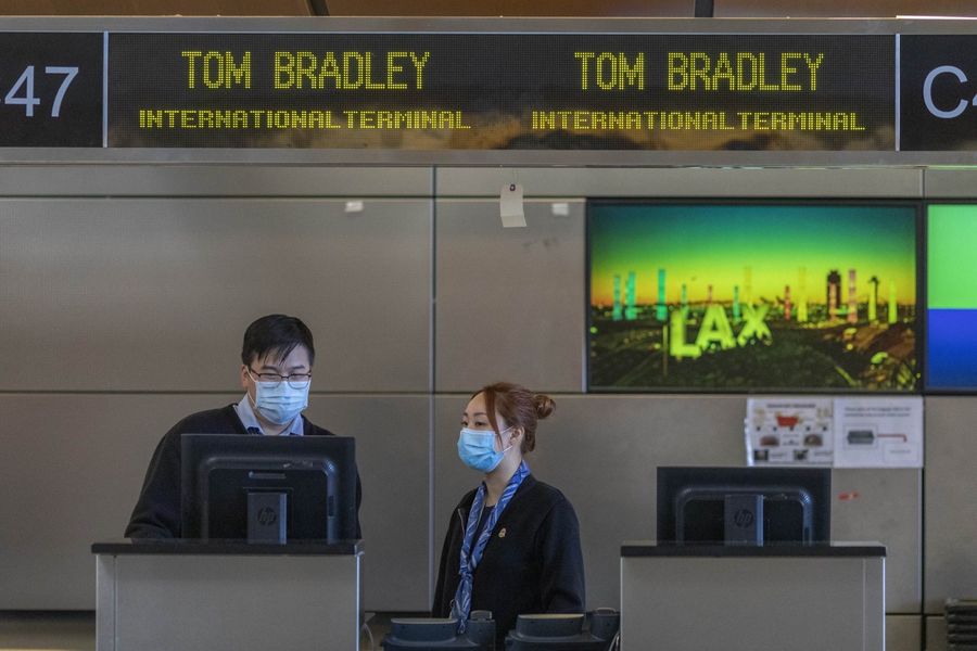 Air China employees wear medical masks for protection against the Covid-19 at LAX Tom Bradley International Terminal on 2 February 2020 in Los Angeles, California. The United States was first to announce a travel ban on travellers from China. (David McNew/Getty Images/AFP)