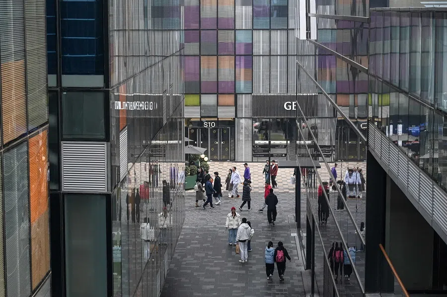 People walk past a shopping mall complex in Beijing, China, on 1 March 2025. (Jade Gao/AFP)