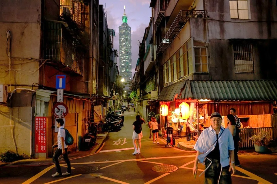 People walk as the Taipei 101 building is seen in the distance, in Taipei, Taiwan, on 9 October 2025. (Ann Wang/Reuters)