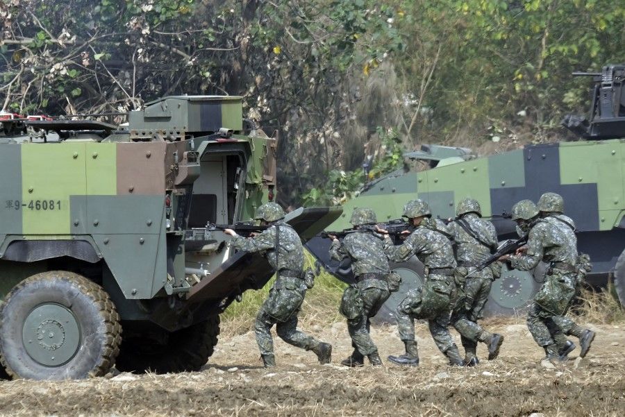 In this file photo taken on 17 January 2017 Taiwan special forces personnel walk behind an armoured personnel carrier during an annual military drill in Taichung, central Taiwan. US special operations forces and marines have been secretly training Taiwanese troops for more than one year, risking the ire of China, The Wall Street Journal reported on 7 October 2021. (Sam Yeh/AFP)