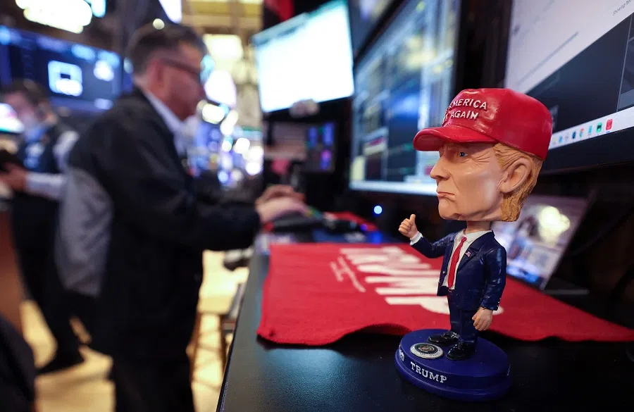 A bobble head depicting US President Donald Trump sits on a desk as traders works on the floor of the New York Stock Exchange (NYSE) at the opening bell in New York City, on 14 April 2025.