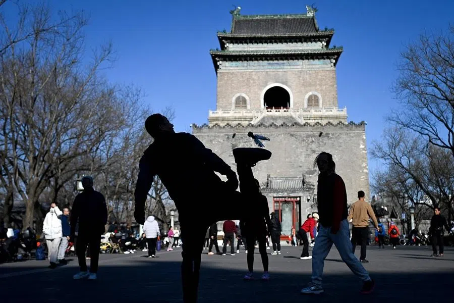 A group of people kicks a shuttlecock at a square in Beijing on 5 January 2026. (Wang Zhao/AFP)