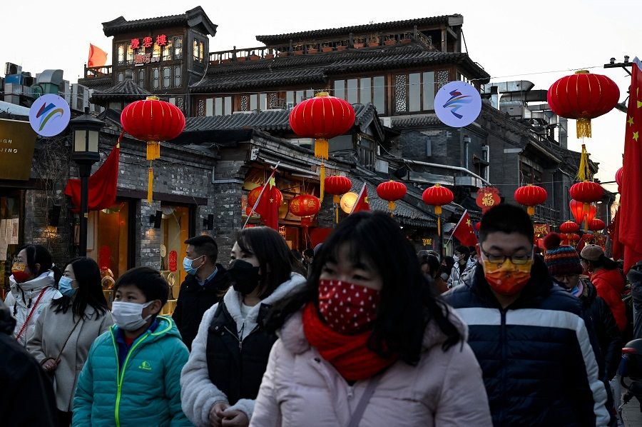 People walk under traditional lanterns in Beijing, China, on 2 February 2022. (Jade Gao/AFP)