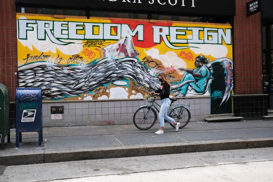 People walk past a boarded up business as stores are preparing for a gradual re-opening in the coming weeks on June 15, 2020 in New York City. (Spencer Platt/AFP)