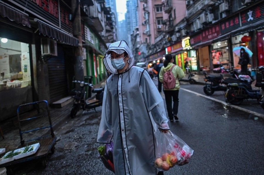 A person carries groceries in a neighbourhood in Wuhan, April 20, 2020. (Hector Retamal/AFP)