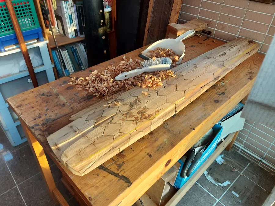 This is known as bainaqin (百衲琴) where the top board is made by piecing together many pieces of leftover high quality tone wood. One normally is not able to see this because the qin is lacquered, so this is an insider view. The shape here would eventually become a banana leaf.