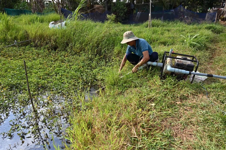 A man installs a water pump in a field in Vietnam’s southern Ben Tre province in Vietnam’s Mekong Delta on 19 March 2024. (Nhac Nguyen/AFP)