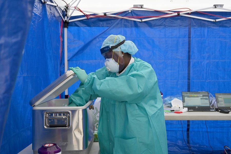 A healthcare worker places a test sample into a cooler box at the Brightpoint Health and UJA -Federation of New York free pop-up coronavirus testing site on 8 May 2020 in the Brooklyn borough of New York City. (Angela Weiss/AFP)