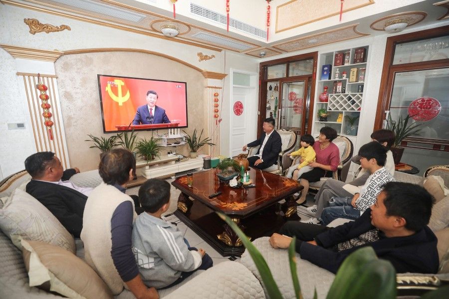 People watch a live broadcast of China's President Xi Jinping speaking during the introduction of the Chinese Communist Party's Politburo Standing Committee, in Huaibei in China's eastern Anhui province on 23 October 2022. (AFP)