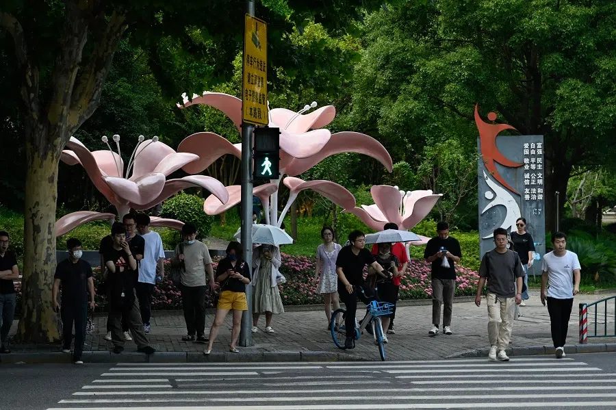 People wait for the green light in Lujiazui district in Shanghai, China, on 29 June 2023. (Pedro Pardo/AFP)